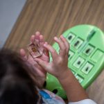 Child examining ladybug specimen in clear block container