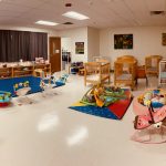 rm4 Daycare room with cribs, toys, and rocking chairs